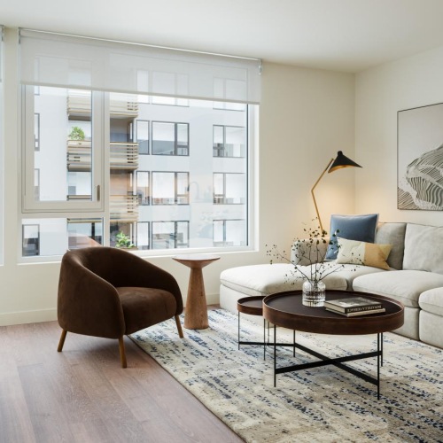 a living room with a couch and a coffee table and a large window