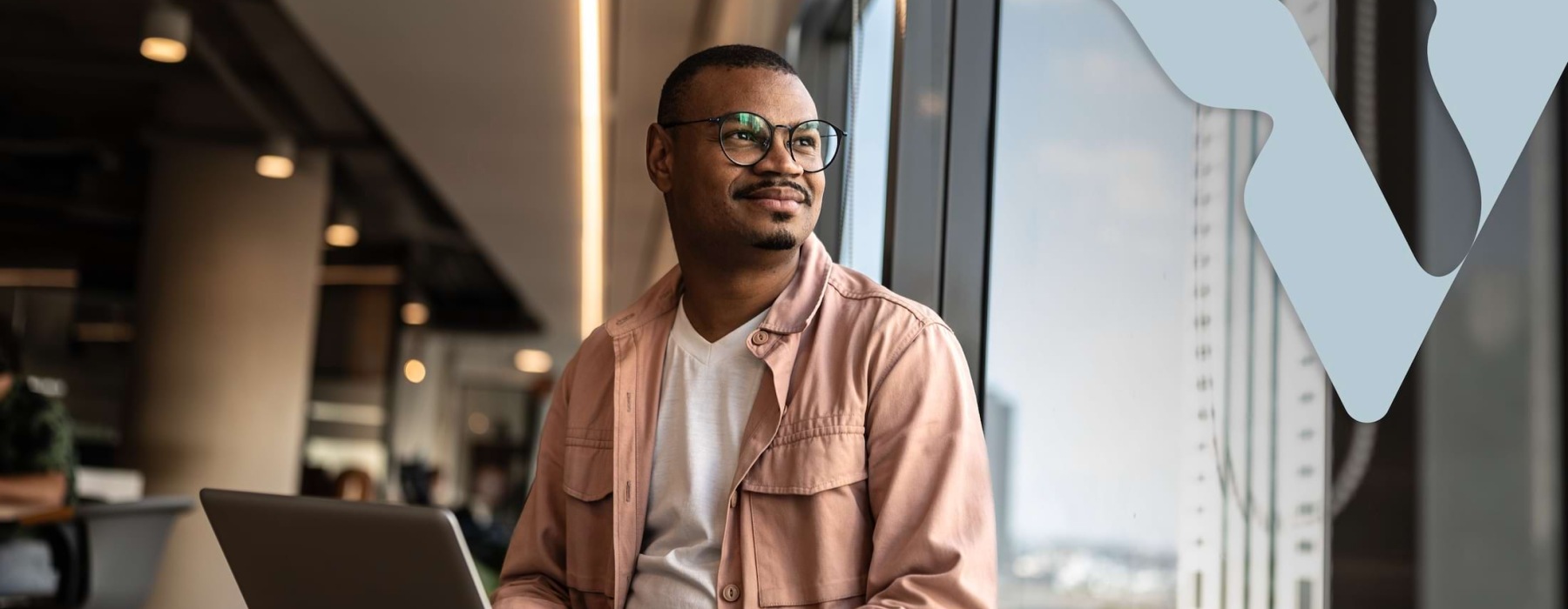 a man wearing glasses gazing out a window